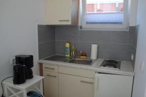 a small kitchen with a sink and a window at Ferienquartier Trassenheide 1 in Trassenheide