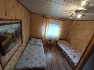 a small bedroom with two beds and a window at Noclegi u Daszyka in Polańczyk