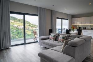 un salon avec deux canapés et une cuisine dans l'établissement Paradise views - Pereira House, à Arco da Calheta 39 autres photos