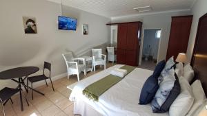 a bedroom with a bed and a table and chairs at Studio 12 @ The Dunes in Plettenberg Bay