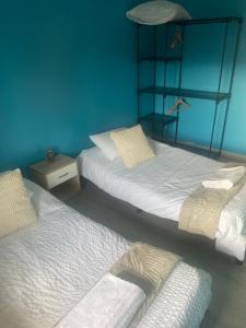 three beds in a room with blue walls at Maison de charme st euphemie in Sainte-Euphémie