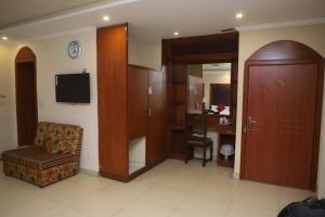 a hotel room with a chair and a desk and a door at PAK Heritage Hotel in Lahore