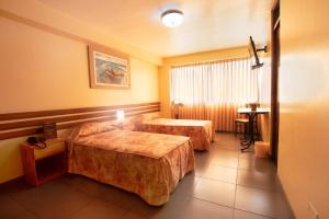 a hotel room with two beds and a table at Hotel Olaya in Lima