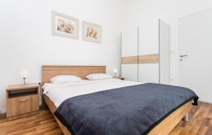 a bedroom with a large bed and a wooden floor at Nives in Šilo