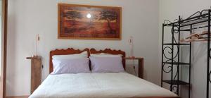 a bedroom with a bed with a picture on the wall at Lu Biulè di Pau in Groscavallo