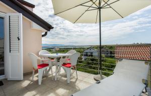 a patio with a table and chairs and an umbrella at Nives in Šilo +5 photos