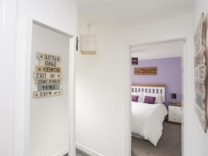 a bedroom with a white bed and a mirror at Bywyd Da 232 Cae Du in Abersoch