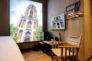 ein Zimmer mit einem Schreibtisch, auf dem ein Computer und ein Tower stehen in der Unterkunft City Center Lodge Utrecht in Utrecht