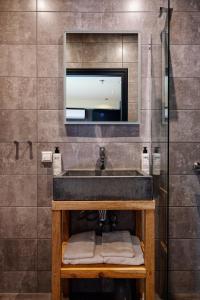 a bathroom with a sink with a tv above it at City Center Lodge Utrecht in Utrecht