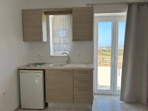 a kitchen with a sink and a sliding glass door at Antiparos Diamond in Antiparos