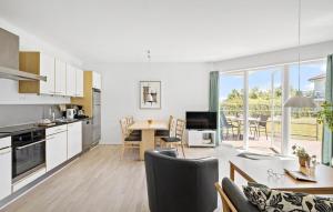 une cuisine et un salon avec une table et des chaises dans l'établissement Gudhjem Søpark Lejl 35, à Gudhjem
