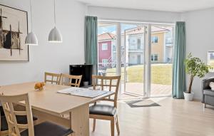 une salle à manger et un salon avec une table et des chaises dans l'établissement Gudhjem Søpark Lejl 35, à Gudhjem 15 autres photos