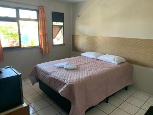 a bedroom with a bed with two towels on it at pousada Sol e Praia in Fortaleza