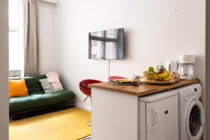Una cocina con una lavadora con un bol de plátanos. en Small and cosy apartment in heart of Helsinki, en Helsinki