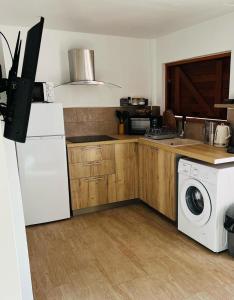 Il comprend une cuisine équipée d'un réfrigérateur blanc et d'un lave-linge. dans l'établissement Aloès, T2 résidence Le Loys à Ste Anne, à Sainte-Anne