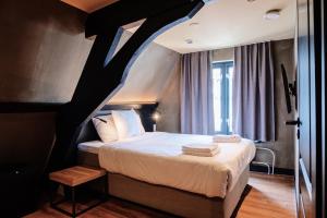 ein Schlafzimmer mit einem Bett und einer schwarz-weißen Decke in der Unterkunft City Center Lodge Utrecht in Utrecht