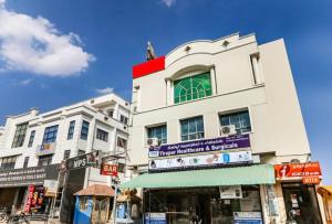 a tall white building with a sign on it at Hotel MPS in Tiruppūr