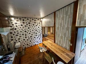佐渡市にあるSADO-Stay02金山京町一軒家貸し切りの木製テーブルと壁のあるダイニングルーム
