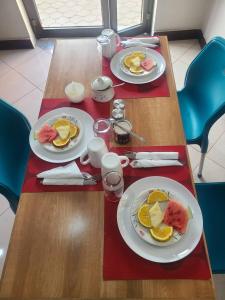 a wooden table with plates of breakfast food on it at Meuly Family Lodge in Arusha