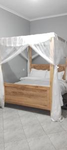 a bed with a canopy in a room at Meuly Family Lodge in Arusha