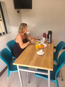 a woman sitting at a table with a plate of food at Meuly Family Lodge in Arusha