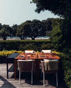 a wooden table with two chairs and sidx sidx sidx at Vila Foz Hotel & SPA - member of Design Hotels in Porto