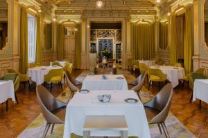a dining room with white tables and chairs at Vila Foz Hotel & SPA - member of Design Hotels in Porto