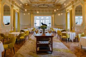 a dining room with tables and yellow chairs at Vila Foz Hotel & SPA - member of Design Hotels in Porto