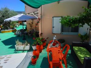 a patio with a table and chairs and potted plants at Trizinia View Garden in Galatas