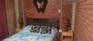 a bedroom with a bed with a brick wall at Apartamentos Agosto in Nueva Galia