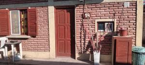 a brick building with a red door and a window at Apartamentos Agosto in Nueva Galia