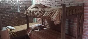 a bedroom with a bunk bed in a brick wall at Apartamentos Agosto in Nueva Galia