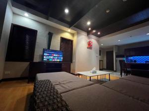a living room with two beds and a flat screen tv at Patong Tower Apartment - AMP in Patong Beach +12 photos