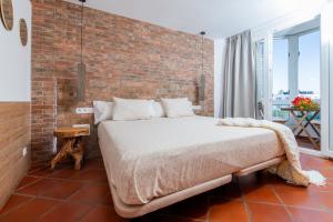 a bed in a room with a brick wall at Calas Beach Corralejo in Corralejo