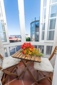 a table and two chairs on a balcony with flowers at Calas Beach Corralejo in Corralejo
