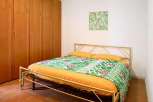 a bedroom with a bed with an orange comforter at Casa Nel Bosco in Sacco