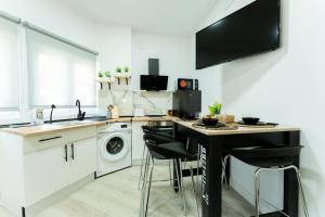 una cucina con un lavello e un tavolo con sgabelli di La palmera apartment a Santander