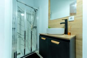 un bagno con lavandino e doccia in vetro di La palmera apartment a Santander
