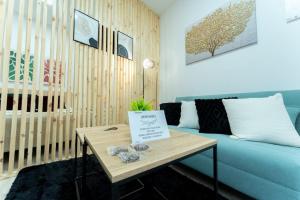 un soggiorno con un divano blu e un tavolo di La palmera apartment a Santander