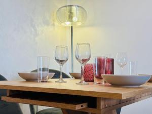 a wooden table with wine glasses and bowls on it at Joy City Stay Forest 84 in Timişoara