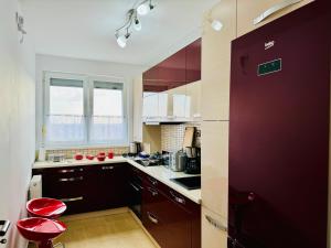 a kitchen with red stools and a red door at Joy City Stay Forest 84 in Timişoara