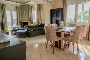 un soggiorno con tavolo, sedie e divano di The Olive House a Dhíkella