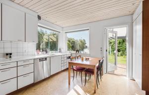 a kitchen with white cabinets and a wooden table at 4 Bedroom Gorgeous Home In Varde in Varde +21 photos