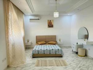 a bedroom with a bed in a white room at Villa Piscine Hergla in Akouda