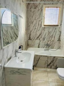 a bathroom with a sink and a tub and a toilet at Villa Piscine Hergla in Akouda +13 photos