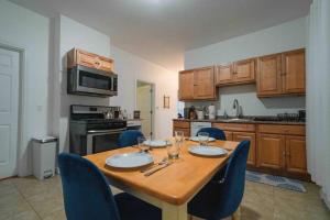 a kitchen with a wooden table and blue chairs at Cozy 2BR-Walk to Tufts & Green Line, Near Boston! in Medford