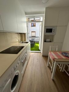 a kitchen with a sink and a washing machine in it at La Aldea 3 , CENTRO de Comillas, Parking Público y vistas Universidad Pontificia in Comillas