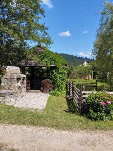 a stone shelter with a fence and flowers at Відпочинковий комплекс "Alpha Plus" in Yablunytsya