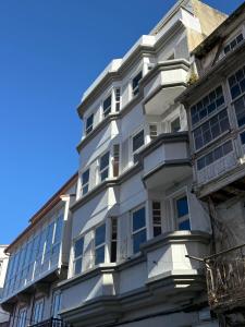 a white building with windows and a blue sky at La Fantástica Pontedeume 4 in Puentedeume +13 photos