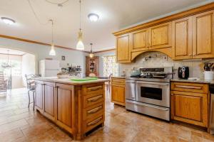 a large kitchen with wooden cabinets and stainless steel appliances at Idilio Escape in Ocho Rios